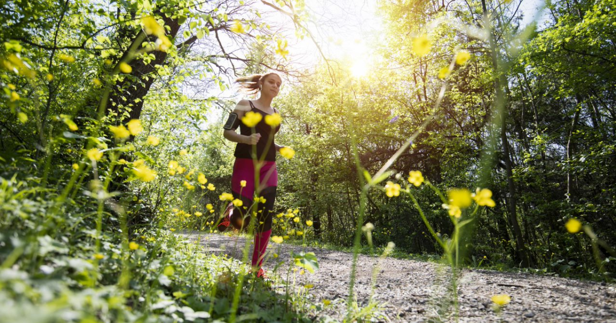 Femme courant dans les bois parmi les fleurs